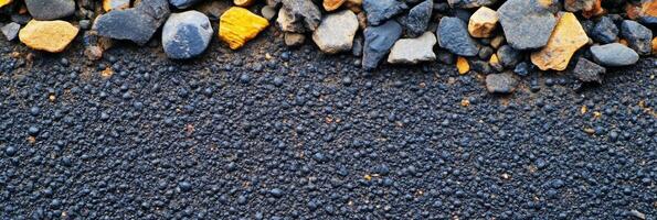 Close-up of textured asphalt with scattered pebbles along the edge. photo