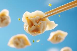 Chopsticks are holding dumplings in the air photo