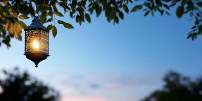 A decorative lantern hangs amid leaves at twilight, casting a warm glow. photo