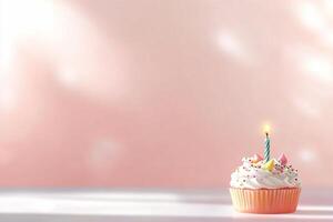 A decorated cupcake with a lit candle against a soft pink background. photo