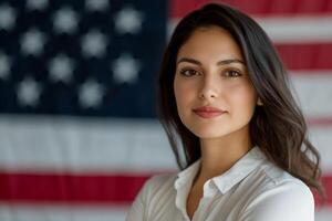 A confident woman poses in front of an American flag. photo