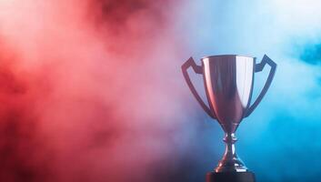 A shiny trophy set against a backdrop of red and blue smoke. photo