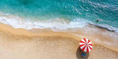 Aerial view of a beach with an umbrella and gentle waves. photo