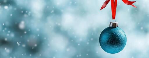 A shimmering blue Christmas ornament hanging against a blurred background. photo