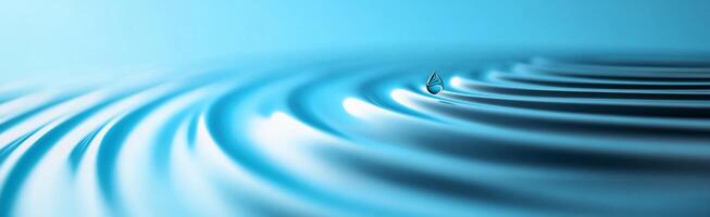A serene blue image depicting ripples in water with a single droplet. photo