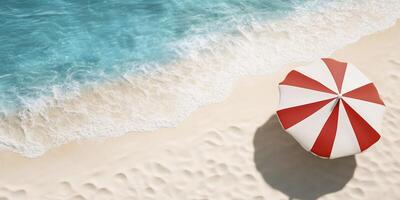 A serene beach scene with a red and white striped umbrella. photo