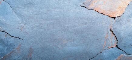 A textured slate stone surface with natural variations in color. photo