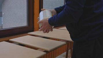 A man shakes a can of paint before using it. The process of mixing paint that has been standing for a long time. Sedimentation of components affects the quality of painting work. video