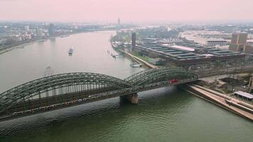 Drohne Aussicht von das hohenzollern Eisenbahn Brücke im Köln, Drohne Filme ein ziehen um Zug auf das Brücke. Transport Austausch Deutschland video
