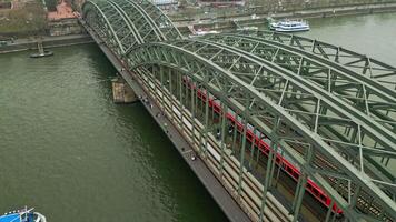 Drohne Aussicht von das hohenzollern Eisenbahn Brücke im Köln, Drohne Filme ein ziehen um Zug auf das Brücke. Transport Austausch Deutschland video