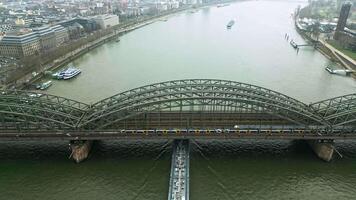 Drohne Aussicht von das hohenzollern Eisenbahn Brücke im Köln, Drohne Filme ein ziehen um Zug auf das Brücke. Transport Austausch Deutschland video