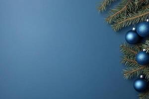 A festive arrangement of blue ornaments and pine branches on a blue background. photo
