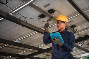 A solar panel engineer monitors the electrical system of his panels using a tablet on his hand photo