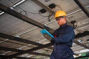 solar panel engineer monitors the electrical system of his panels using a tablet photo