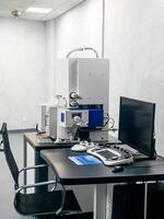 Work space of a scientist with Electron microscope, table and computer photo