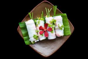Vietnamese Pho spring roll with seafood, tofu, vegetables isolated on black background for a menu top view photo