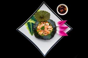 Vietnamese fried rice with vegetables, nuts and shrimps in lotus leaf isolated for a menu photo