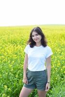 Russian woman standing in rapeseed field and looking at the camera photo
