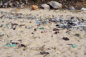 Terrible view of dirty beach in Khanh Hoa province with much trash on stones photo