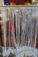 Example of simple leaves pattern knots of macrame technique made of white threads photo