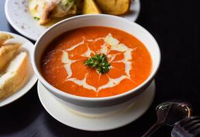 Lunch set made of tomato cream soup, salad, with potato, lemonade on black background photo