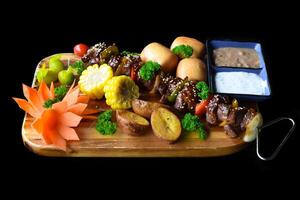 Beef skewers with pepper and corn served with vietnamese buns on black background top view photo