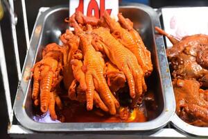 Vietnamese favorite snack braised chicken paw in chili sauce in vietnamese night market in Da Lat photo