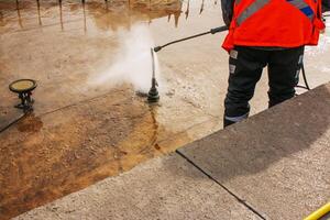 Man uses an electric pressure washer for pressure washer. Cleaning city fountains in autumn. Workers remove the dirt that has settled during the season. photo