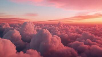 A breathtaking aerial view of a vibrant sunset over a field of puffy clouds. Soft pink and orange hues paint the sky, with a myriad of fluffy clouds below photo