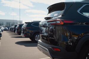 A row of black suvs parked in a parking lot photo
