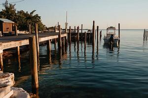 Sunrise dock with small boat. Wooden piers over calm water photo