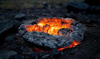 A fire is burning in a pit with rocks photo