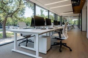 Modern office workspace with large windows. Open layout, featuring rows of white desks, ergonomic chairs, and computer monitors, overlooking a tree-lined park photo