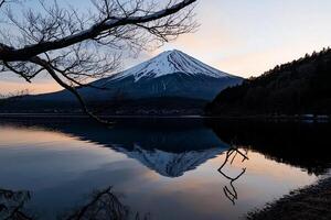 Mountain peak reflected in serene lake at dawn. Snow-capped peak, tranquil waters photo