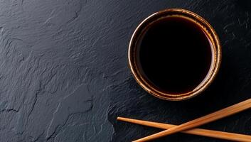 Dark soy sauce in a bowl on dark slate photo