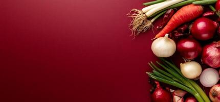 Assorted fresh vegetables arranged on a burgundy surface photo