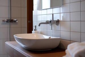 A bathroom sink with a white bowl sitting on a wooden counter photo