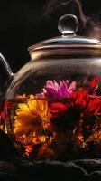 Blooming floral tea inside a dark glass teapot with warm tones and dramatic shadows enhancing colorful flowers unfurling photo