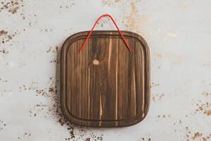 Wooden board with a red string loop adorned with subtle gold specks photo