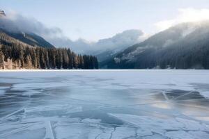 Frozen lake with intricate ice patterns, surrounded by snowy trees photo