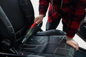 Cleaning the interior of the car with a vehicle vacuum cleaner. photo