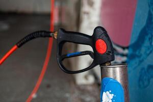 Pistol with a hose with pressurized water at a self service car wash photo