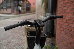 Close-up of a bicycle handlebar with a bell and sticker, blurred bikes in the background photo