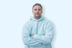 Young caucasian smiling happy cheerful bearded attractive handsome student man 20s wearing casual blue hoodie looking camera isolated on blue background studio portrait People lifestyle concept photo