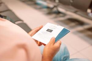 Qr code, check in and man with a phone for a ticket, airplane booking and information at airport. Travel, website and hand of a businessman reading a barcode on a mobile for a work trip or vacation photo