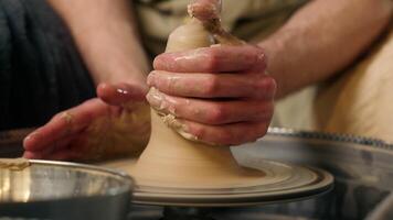 Hands of unrecognizable man master craftsman potter sculpting shaping making new clay product work process male small business artisan modeling wet pottery pot jug handcraft sculptor studio workshop video