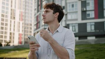 Confused Caucasian man using mobile phone smartphone geolocation looking around tourist male businessman business city puzzled guy searching location lost navigation outdoors urban app GPS navigator video