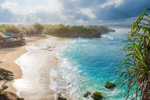Paradise beach with ocean and cloudy sky with sun rays in Lembongan island photo