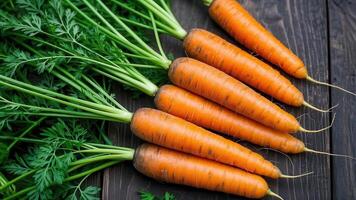 A bunch of carrots with their green tops still attached. Carrots are rich in vitamins and fiber. photo