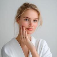 Woman checking her skin after applying face cream photo